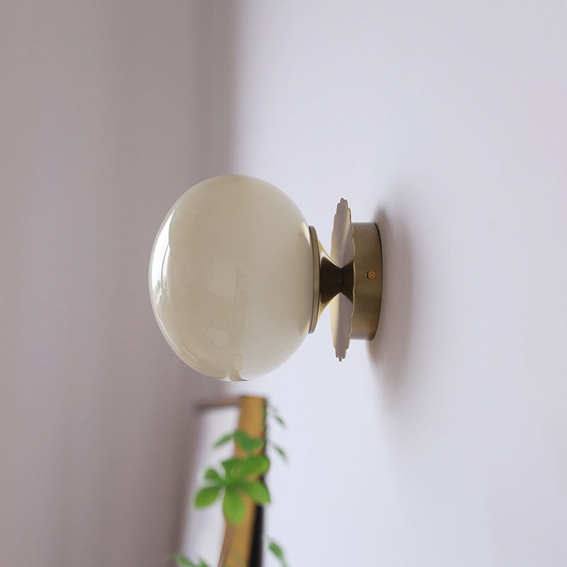 Modern, minimalist 1-light wall lamp made of iron glass with a round head in pink, beige, and white