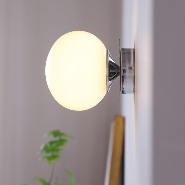 Modern, minimalist 1-light wall lamp made of iron glass with a round head in pink, beige, and white