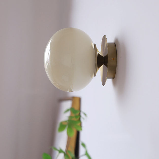 Modern, minimalist 1-light wall lamp made of iron glass with a round head in pink, beige, and white