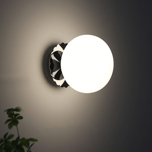 Modern, minimalist 1-light wall lamp made of iron glass with a round head in pink, beige, and white