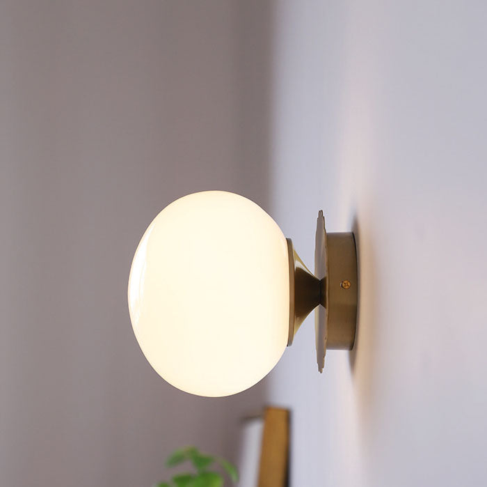 Modern, minimalist 1-light wall lamp made of iron glass with a round head in pink, beige, and white