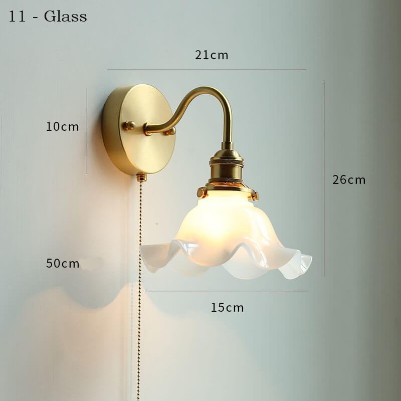 Clear glass wall lamp with pull chain switch, featuring a copper holder for durability and style.