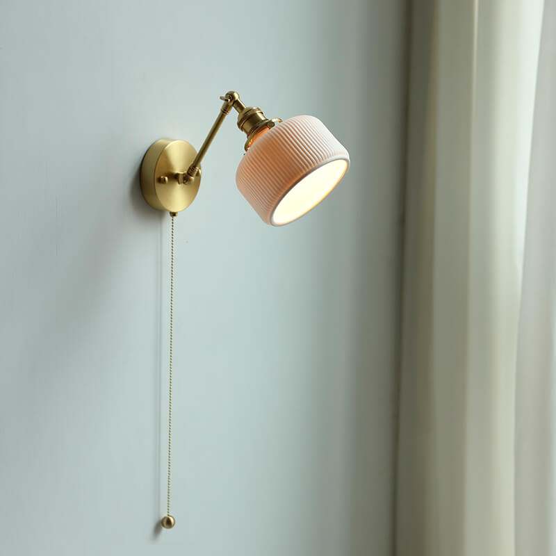 Modern ceramic wall lamp with adjustable arm and pull chain switch, mounted on a copper fixture.