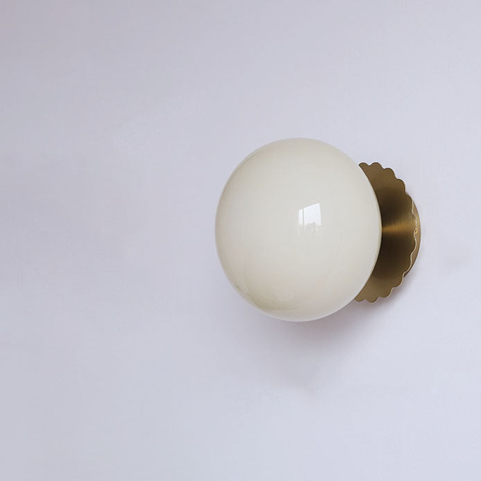 Modern, minimalist 1-light wall lamp made of iron glass with a round head in pink, beige, and white