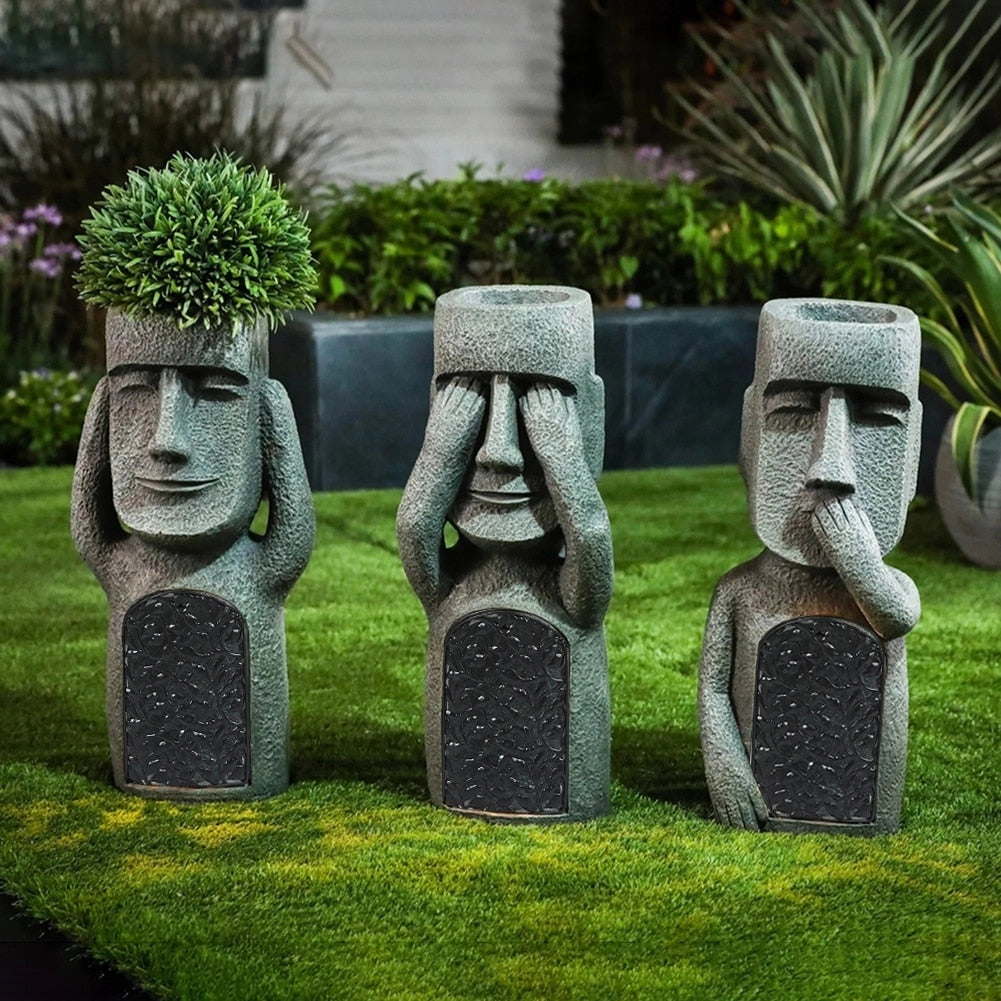 25cm granite Moai statue resembling an Easter Island sculpture placed on a vibrant green lawn surrounded by plants, serving as a garden decor piece.