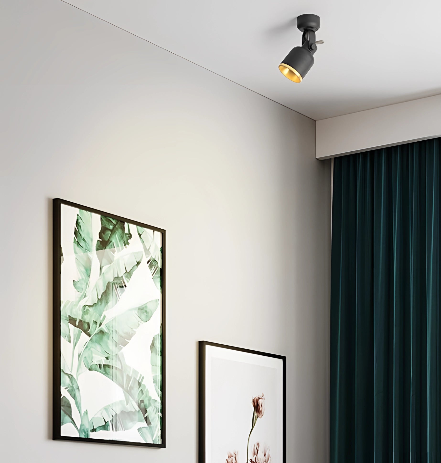 Adjustable black and gold LED track light illuminating a modern interior space, highlighting a picture frame on the wall with curtains in the background.