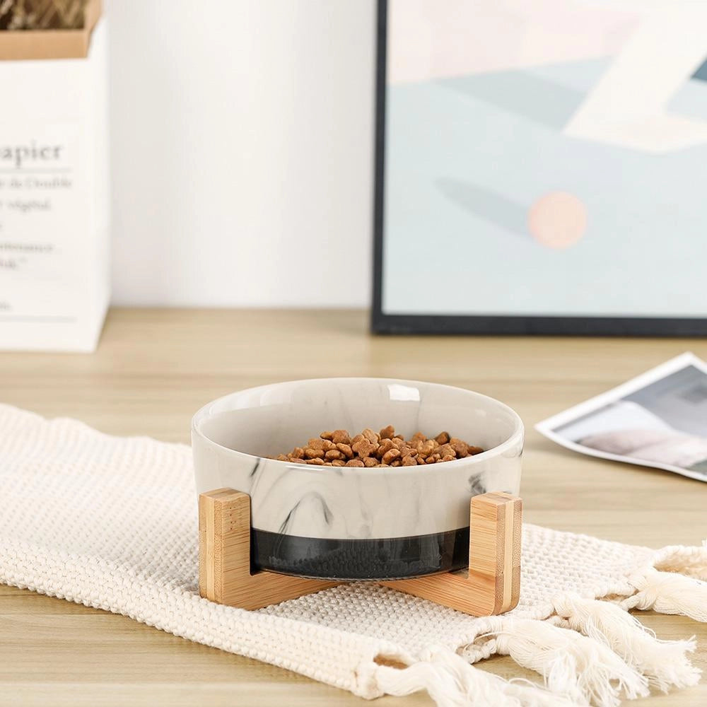 Adjustable multi-level bamboo pet feeder with colorful dishes, featuring wooden construction and vibrant dishware designed for serving pet food.