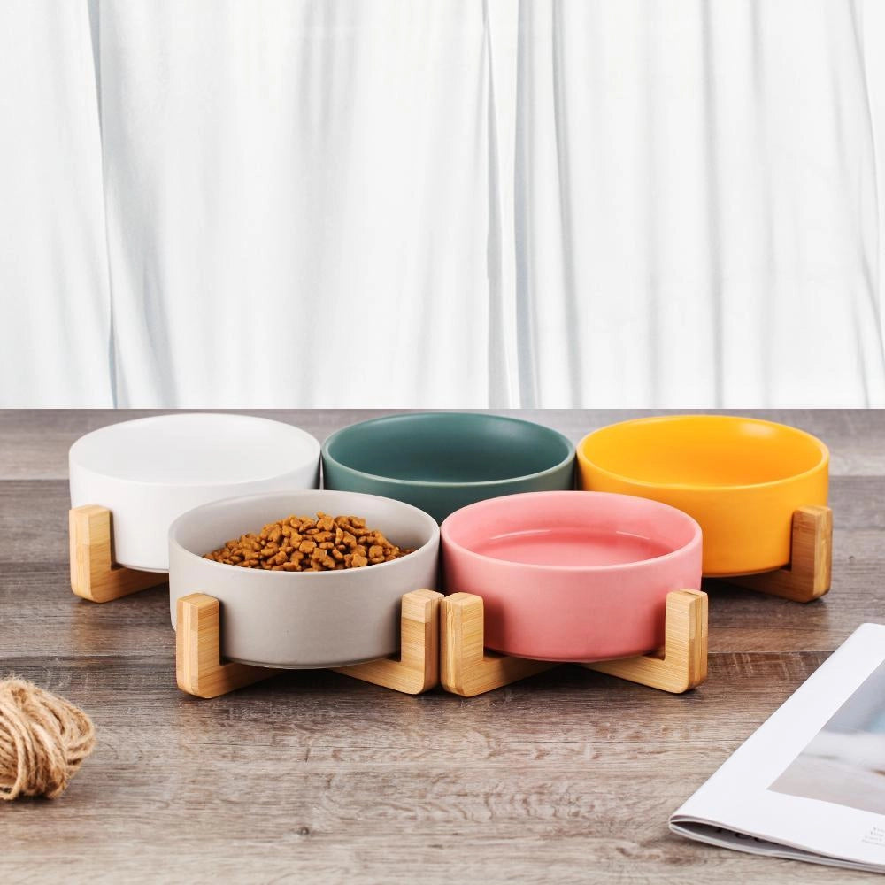 Adjustable multi-level bamboo pet feeder with colorful dishes, showcasing a set of vibrant food bowls arranged on a rectangular bamboo stand designed for convenient pet feeding.