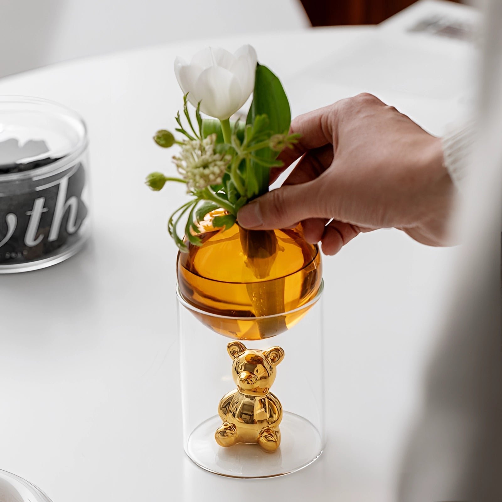 A luxurious amber glass sphere accompanied by a gold bear figurine, styled as an elegant decor piece, with elements suggesting use in a sophisticated setting, possibly featuring drinkware or serveware, hinting at themes of opulence and fine dining.