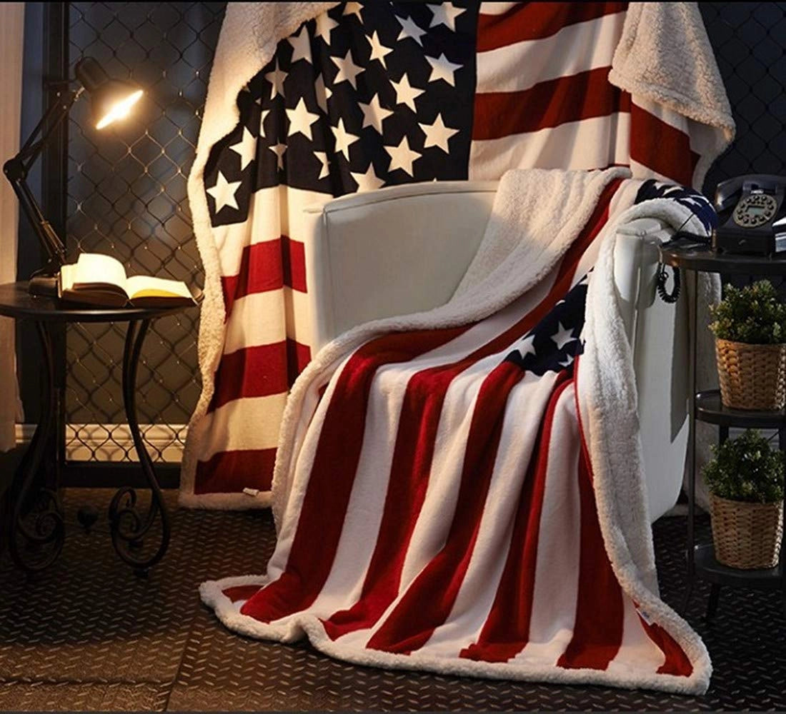 American Flag Fleece Blanket featuring a cozy design with patriotic stars and stripes draped elegantly, surrounded by decorative houseplants in flowerpots, creating a warm and festive atmosphere.