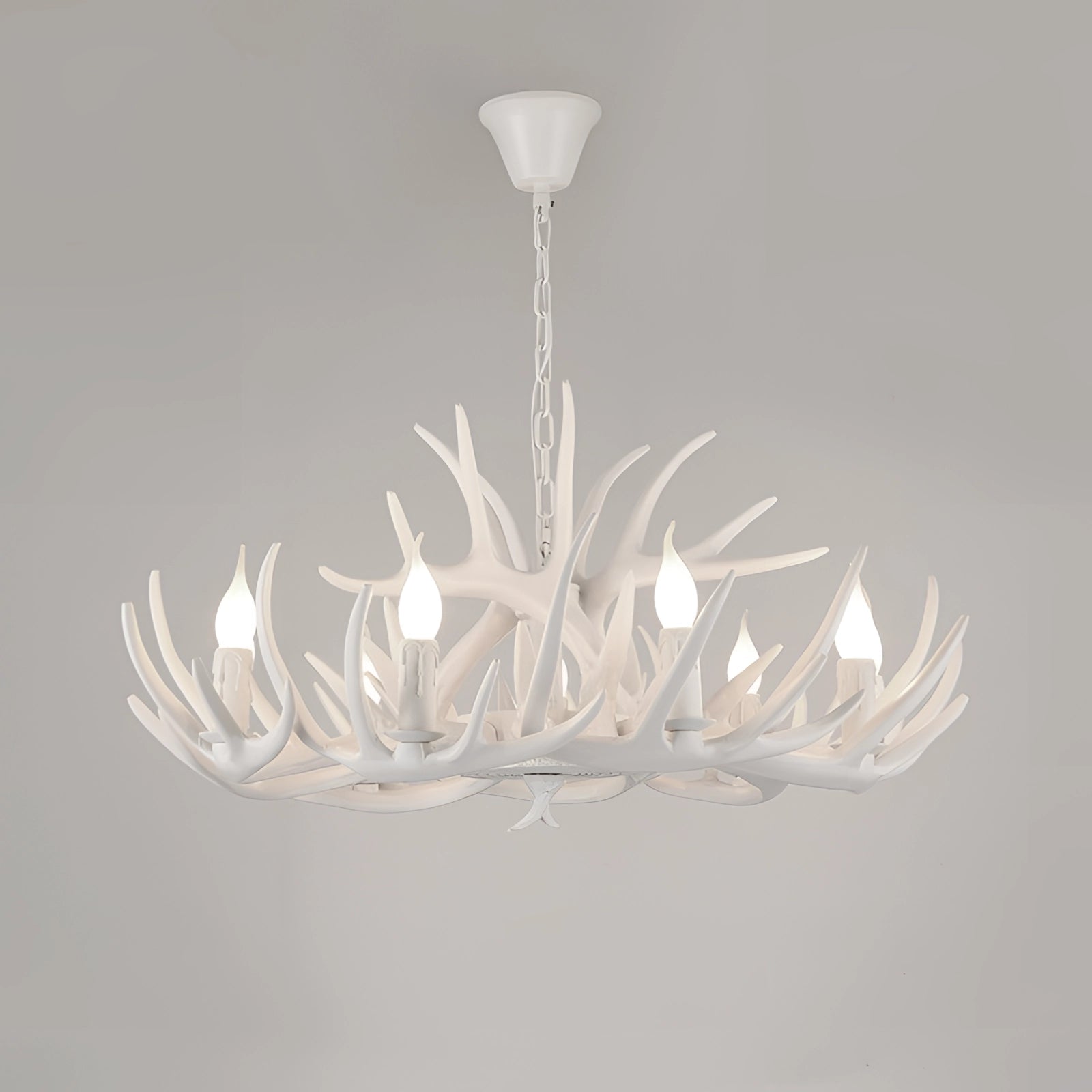 Antler chandelier with a rustic lodge cabin style, featuring a white finish and 10 lights, designed to resemble intertwined twigs and branches, mounted on the ceiling.