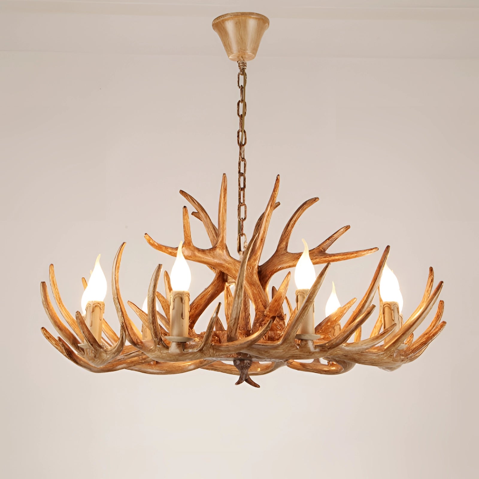 Antler chandelier with a rustic lodge cabin design, featuring natural wooden and metal materials, resembling intertwined twigs and branches, hanging from the ceiling as a decorative lighting fixture.