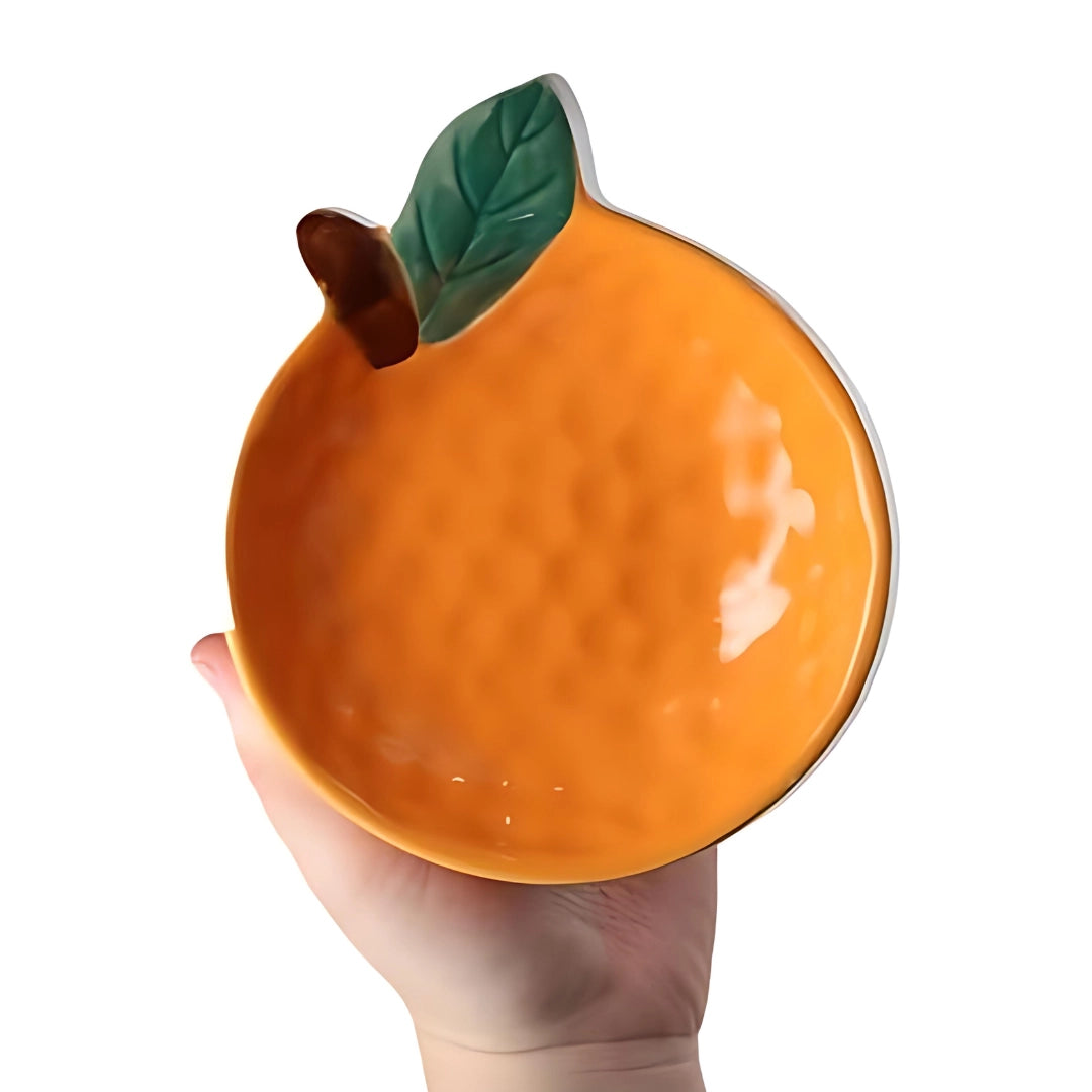 Apple-shaped ceramic mug in orange, resembling a piece of fruit, displayed on a surface; a novelty drinkware item, ideal for themed kitchen settings or as a quirky gift.