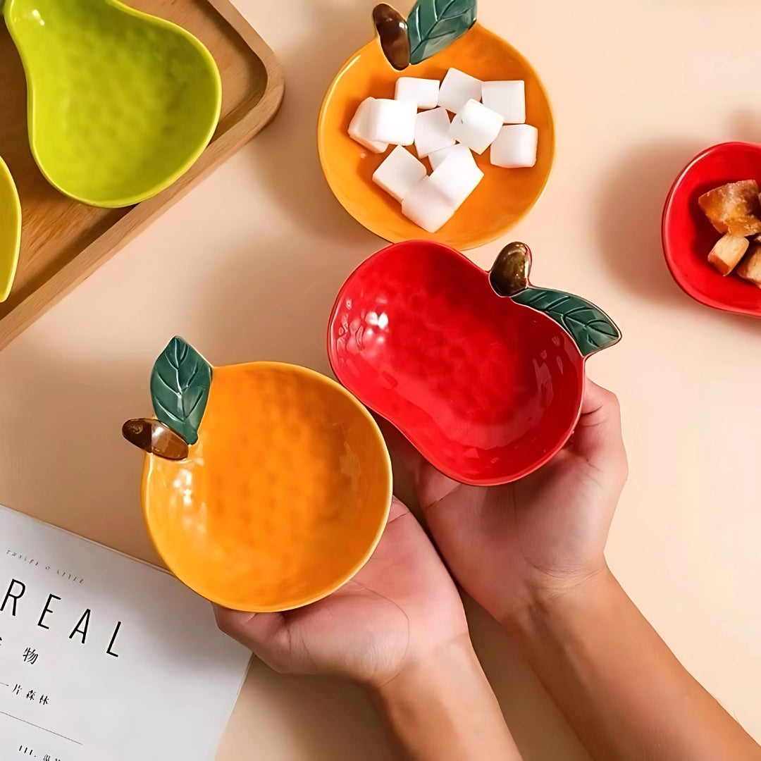 Apple-shaped red ceramic mug with a fruit-themed design displayed on a white background.