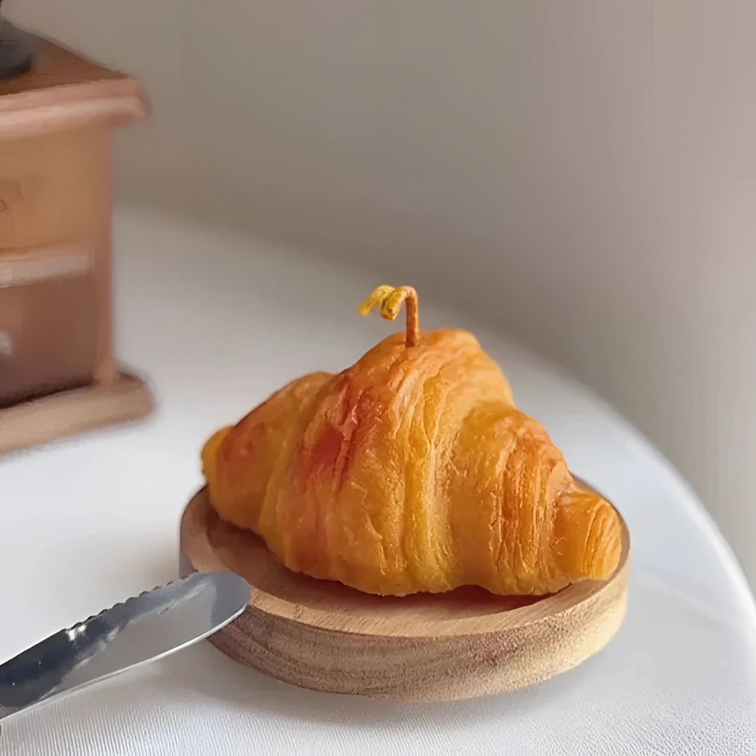 Flaky, golden-brown artisan croissant displayed on a wooden table, highlighting its gourmet design and intricate layers.