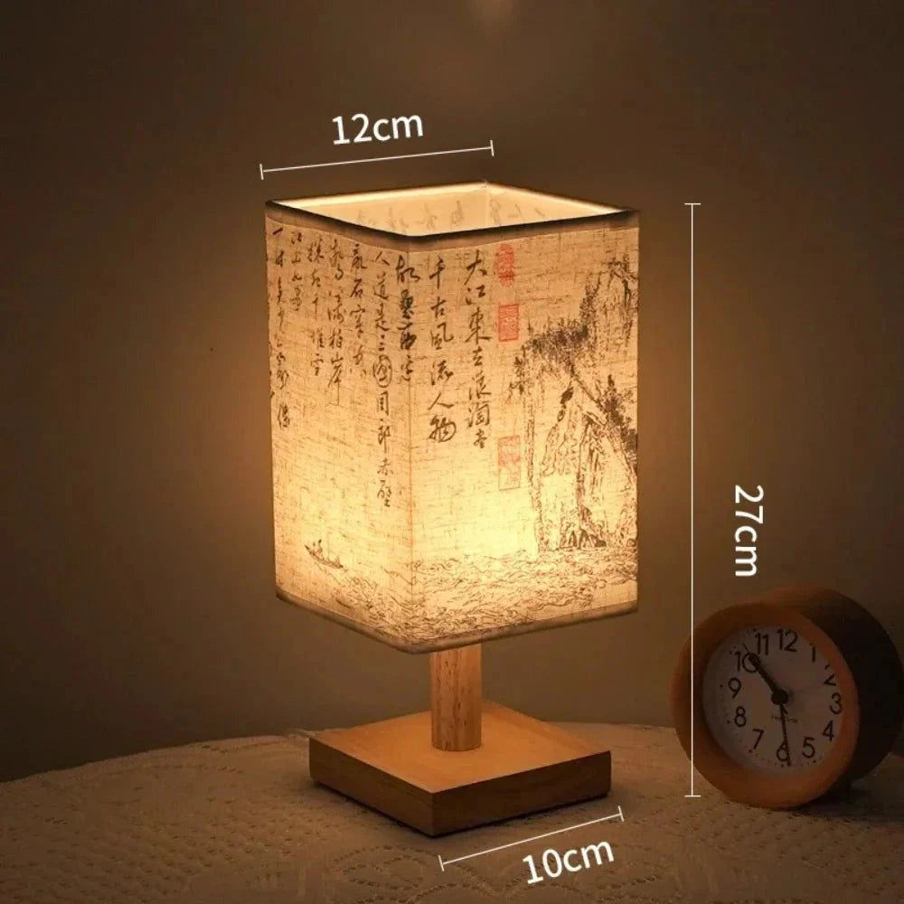 Asian calligraphy lamp with a wooden base, featuring a compact design measuring 27cm. The lamp is illuminated with a warm amber light, showcasing intricate calligraphy art on its surface. This version comes with a USB connector for convenient power supply.