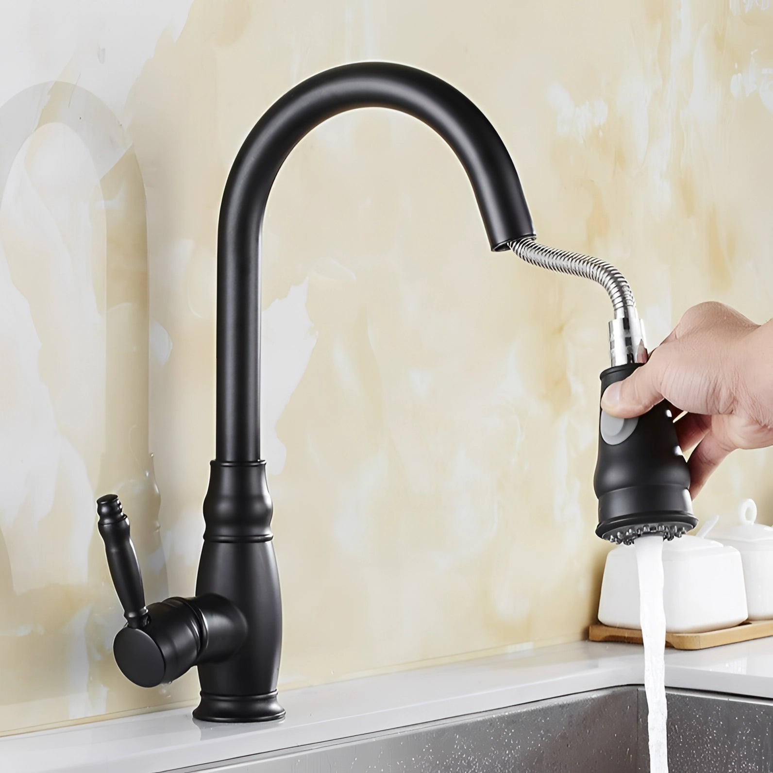 Sleek black kitchen faucet with a pull-down sprayer and single handle design, installed on a modern kitchen sink.