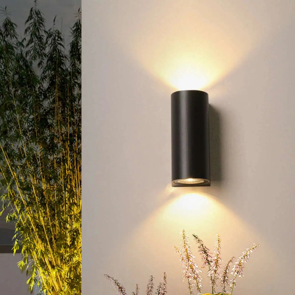 Black LED Cylindrical Outdoor Wall Lamp with Modern Weather-Resistant Sconce, illuminated in a dark setting.