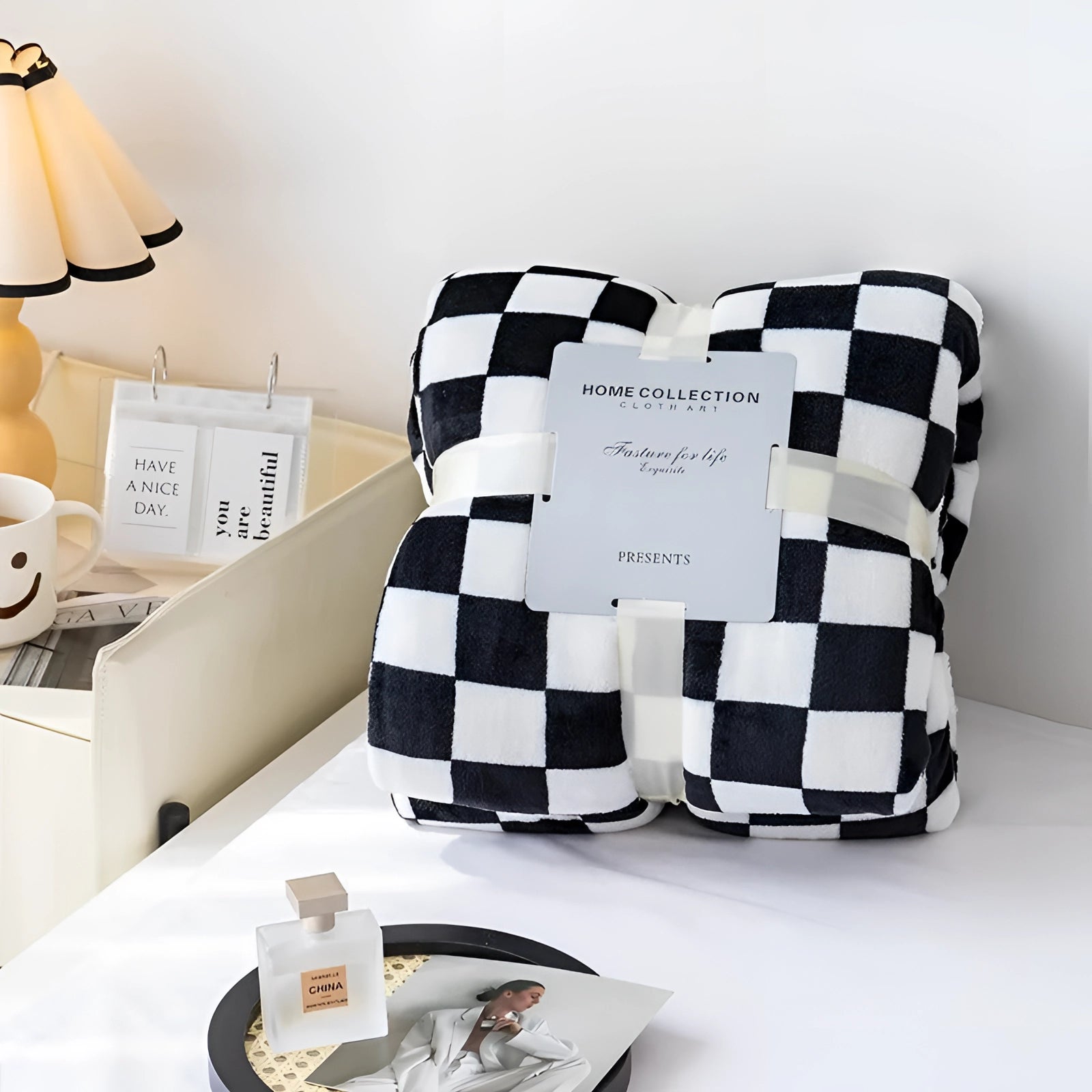 Black and white checkered blanket with a modern geometric pattern draped over a chair next to a table with a lamp.