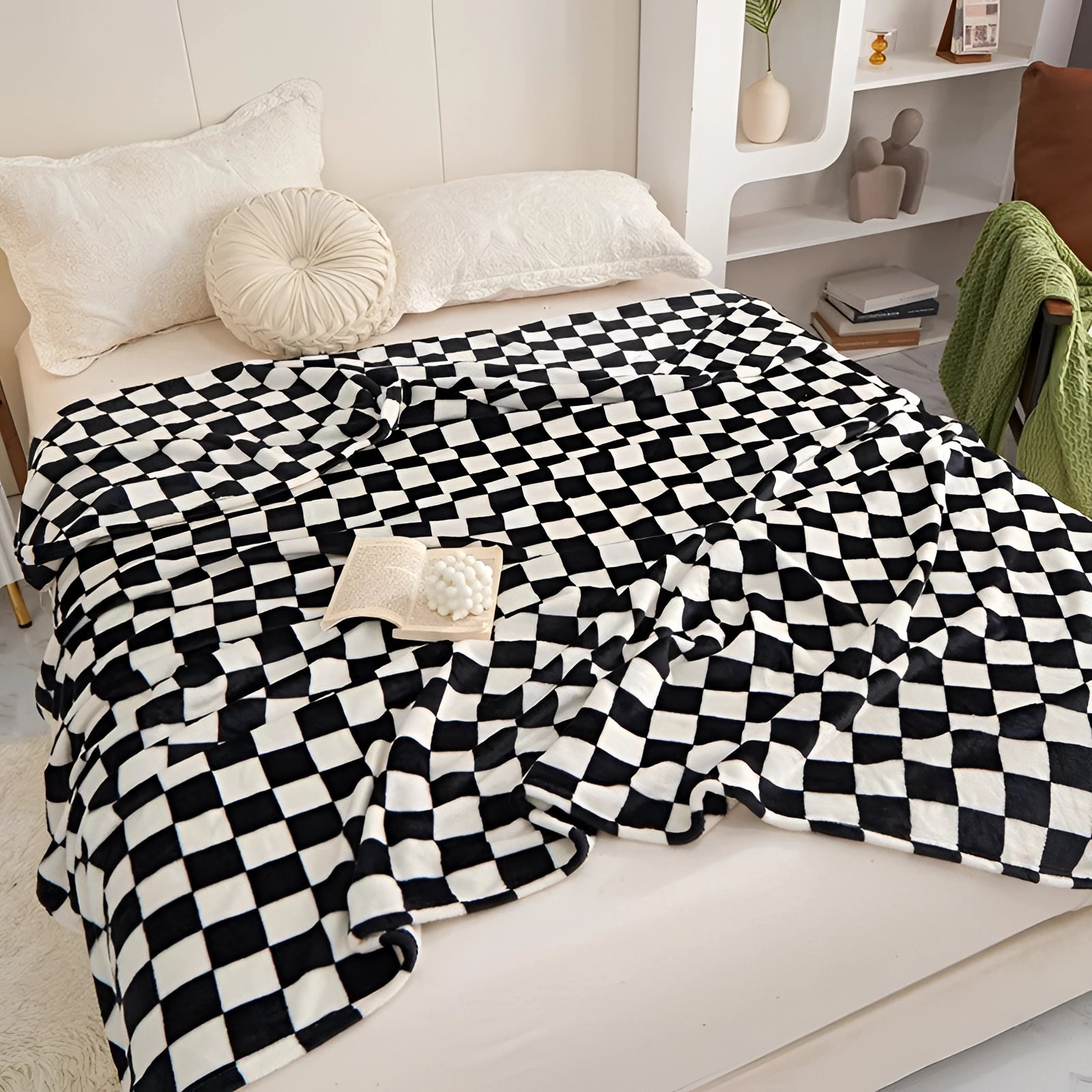 Black and white checkered blanket with a modern geometric pattern draped over a piece of furniture in a well-lit interior setting with a window in the background.