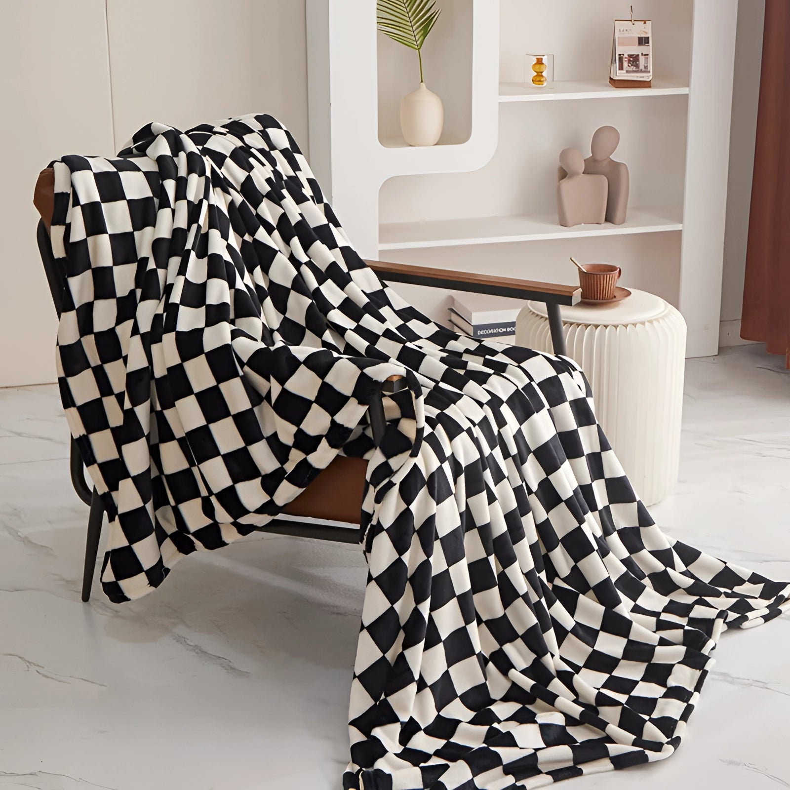 Black and white checkered blanket with a modern geometric pattern draped over a table in a stylish, contemporary interior setting.