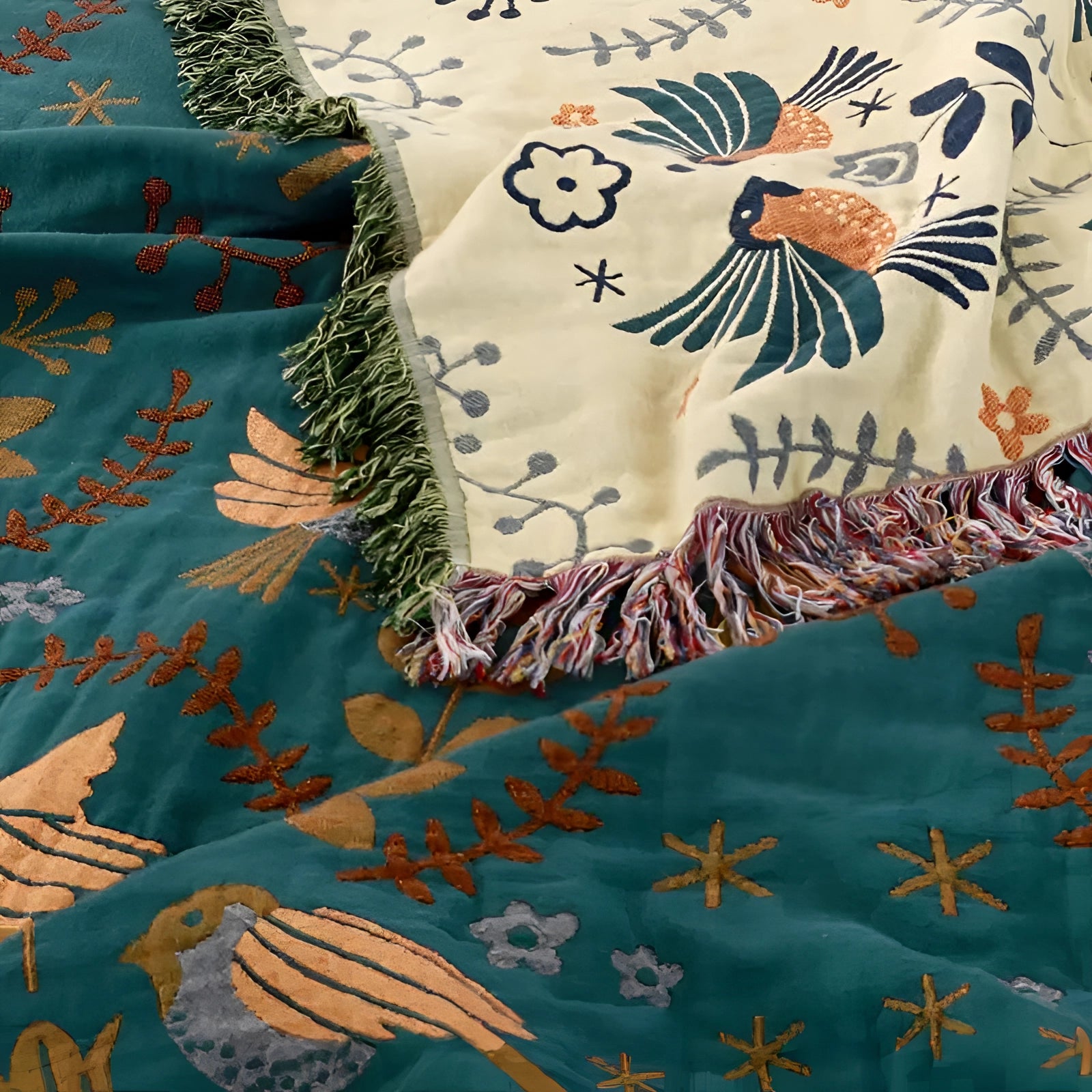 Bohemian Bird Pattern Throw Blanket in blue and beige with a fringed edge, featuring an artistic design of leaves, branches, and birds, creating a nature-inspired textile pattern.