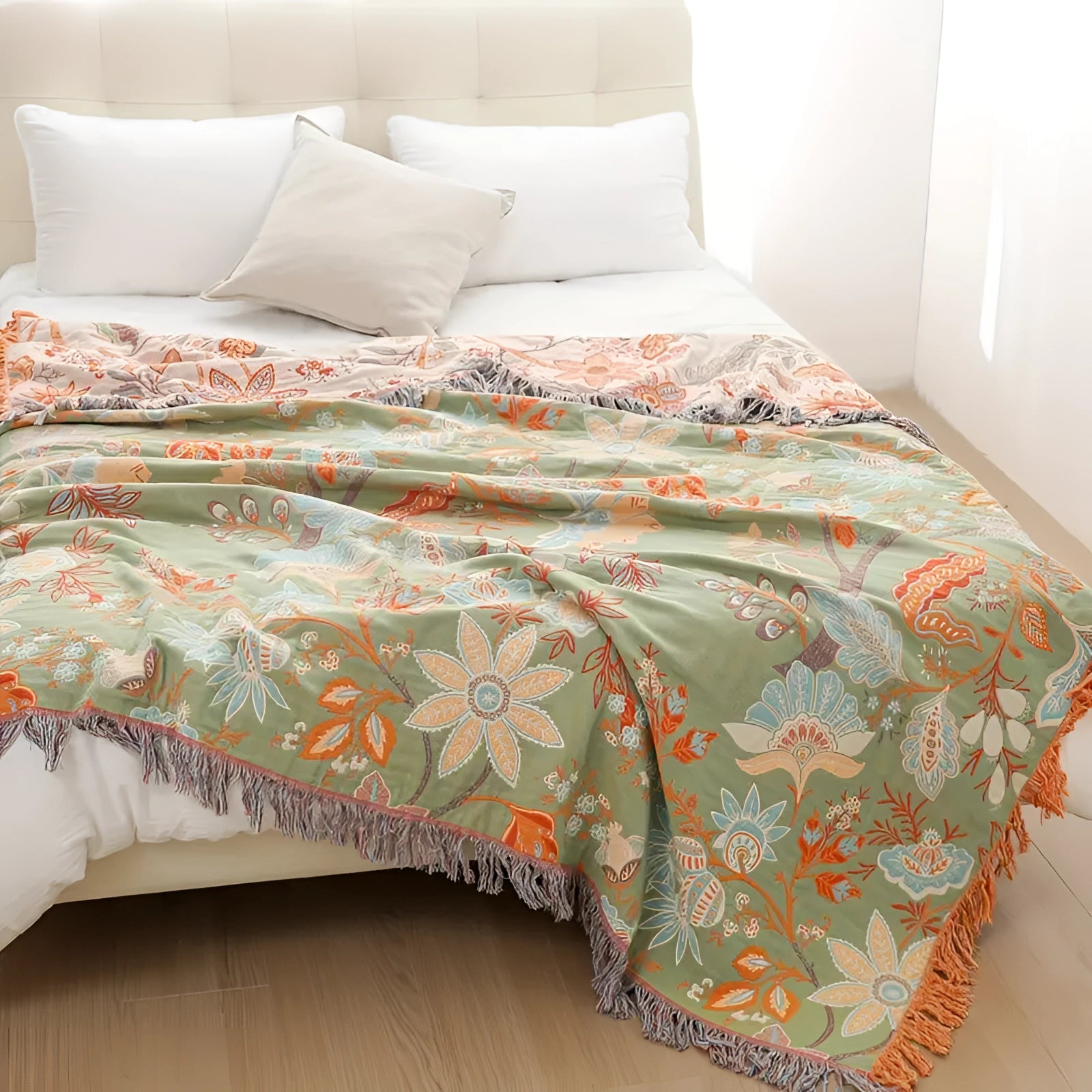 Bohemian Floral Fringed Throw Blanket draped over a piece of furniture in a cozy interior setting, featuring soft cotton material with an orange and white floral pattern and fringed edges, enhancing the room's bohemian aesthetic.