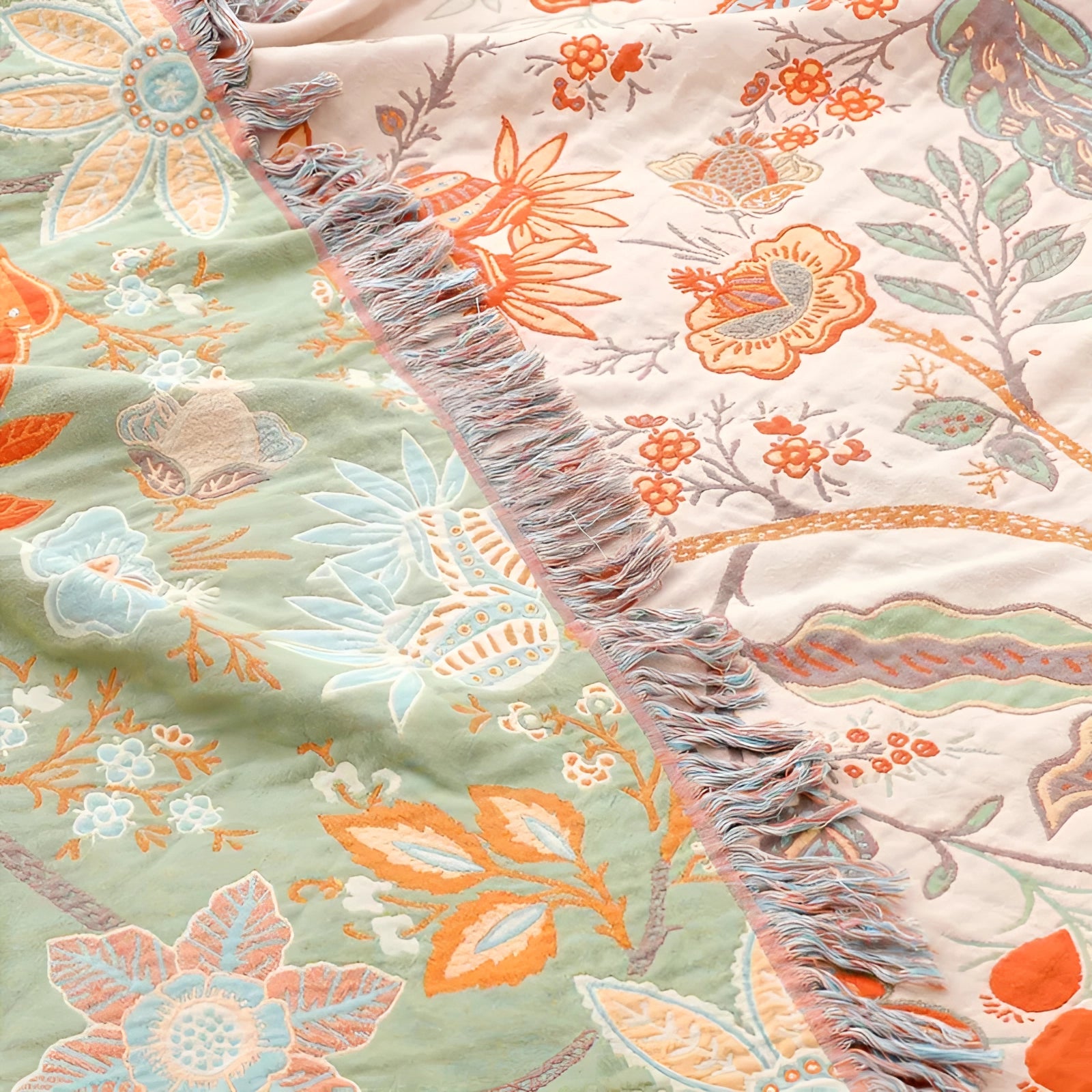 Bohemian floral fringed throw blanket in soft and cozy cotton featuring a colorful pattern with brown, orange, and aqua motifs, and leaf designs.