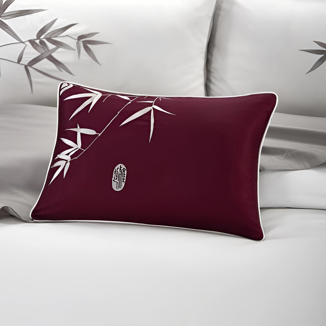 Burgundy embroidered silk pillow with an Asian-inspired pattern, featuring a rectangular shape and magenta tints, ideal for luxury decor and comfort.