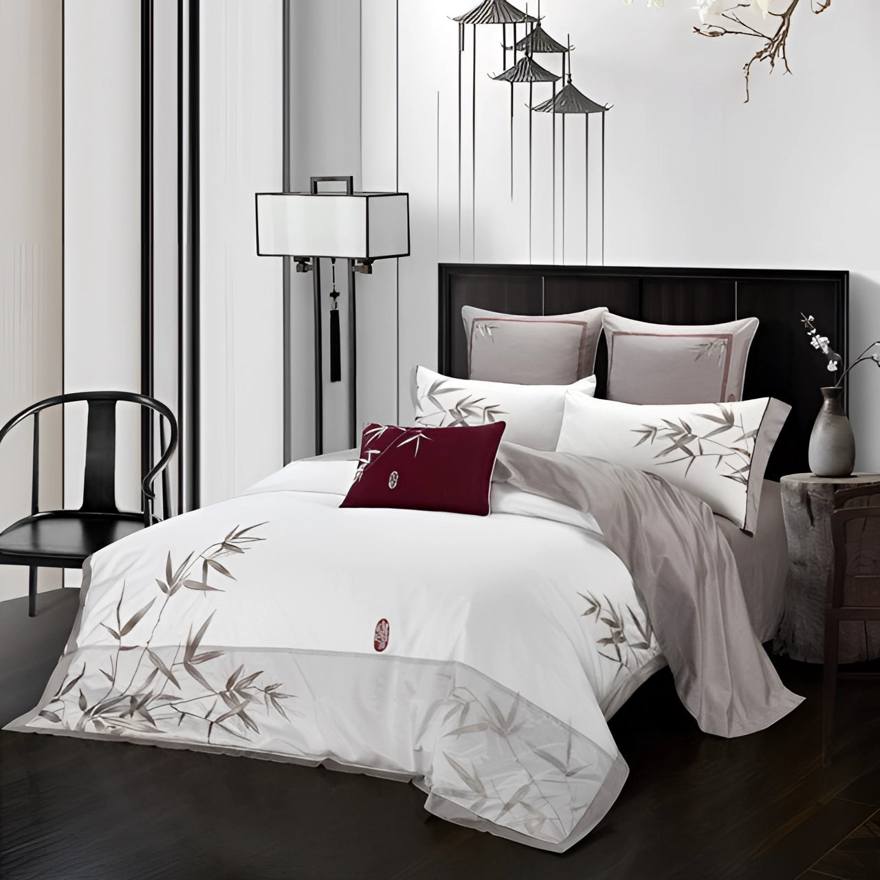 Burgundy embroidered silk pillow on a king-sized bed, showcasing Asian-inspired luxury decor with intricate patterns and rich textures, complemented by a stylish white bed frame and elegant wood flooring in a sophisticated interior setting.