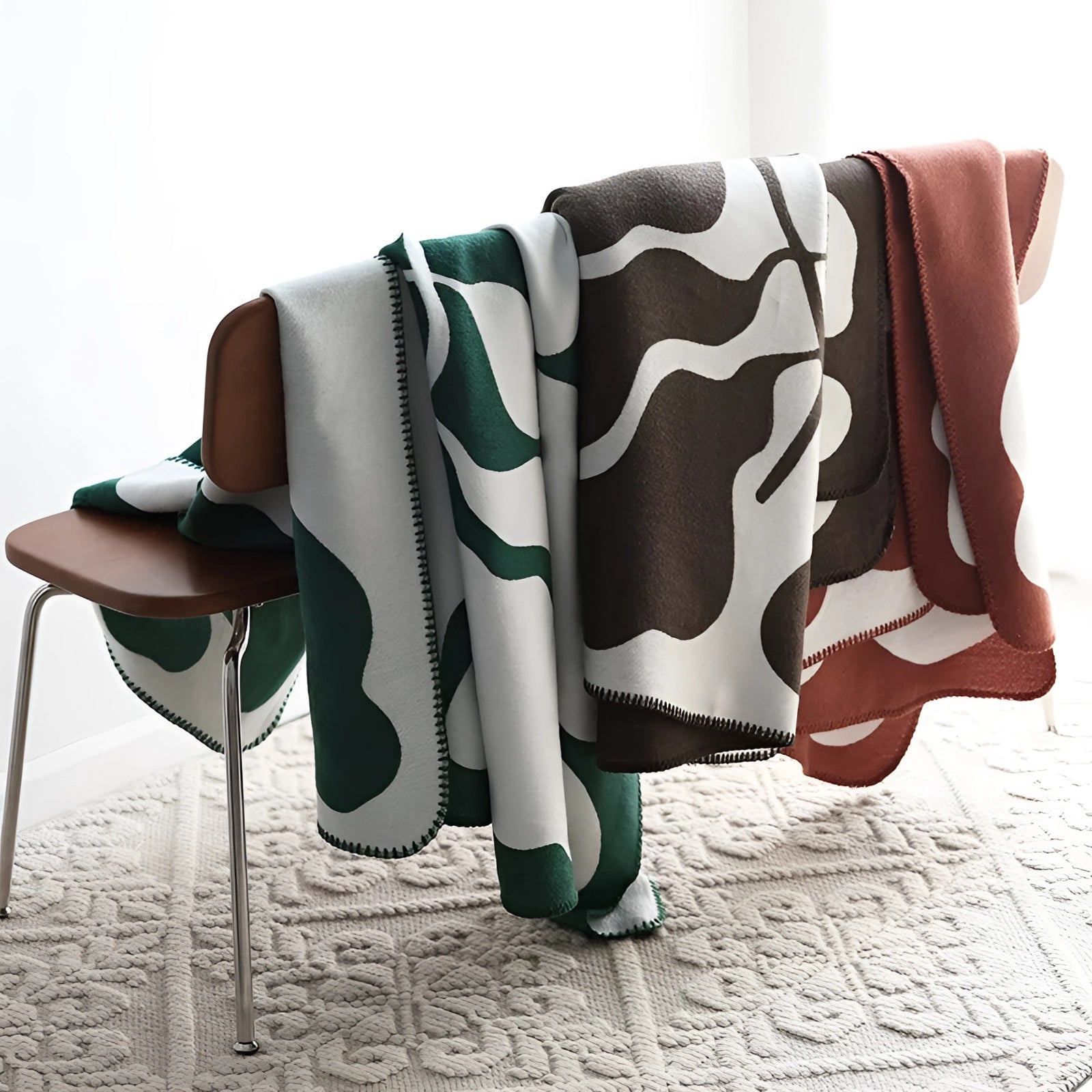 Brown and white cow print throw blanket with animal pattern fleece draped over a person's legs, showcasing its comfort and warmth.