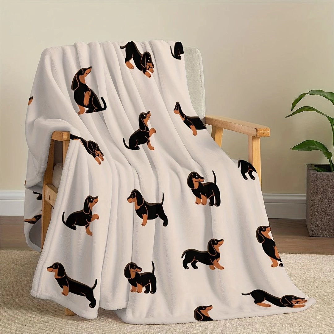 Dachshund-themed fleece blanket draped over a couch, featuring a playful sausage dog design, suitable for pet lovers.