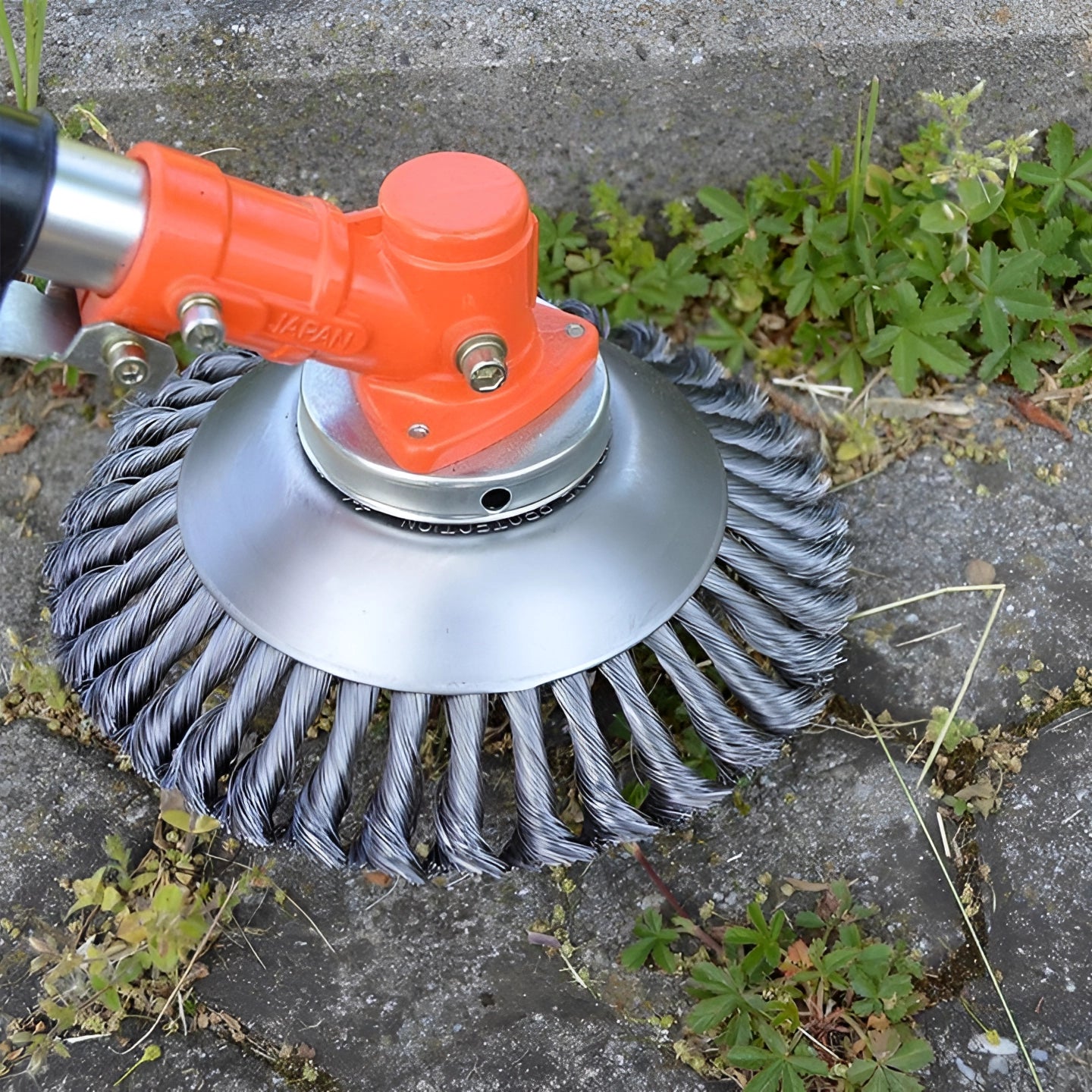 A circular, stone-safe hard block weeding brush designed for efficiently removing weeds, attached to a wheel system with automotive tire and rim visible in the background.