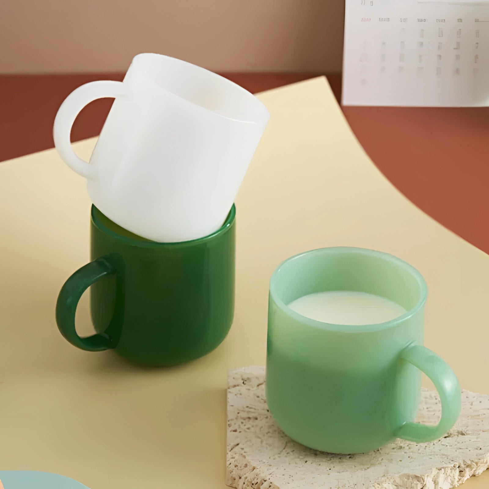 Elegant dark green jade frosted glass mug with a modern minimalist design placed on a table.