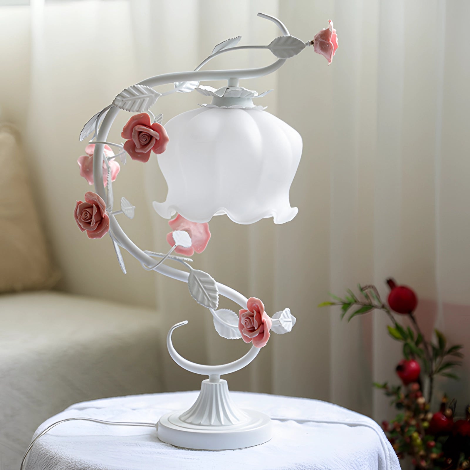 Elegant pink rose table lamp with shabby chic floral vine design on a table, adding a touch of vintage charm to the interior decor.