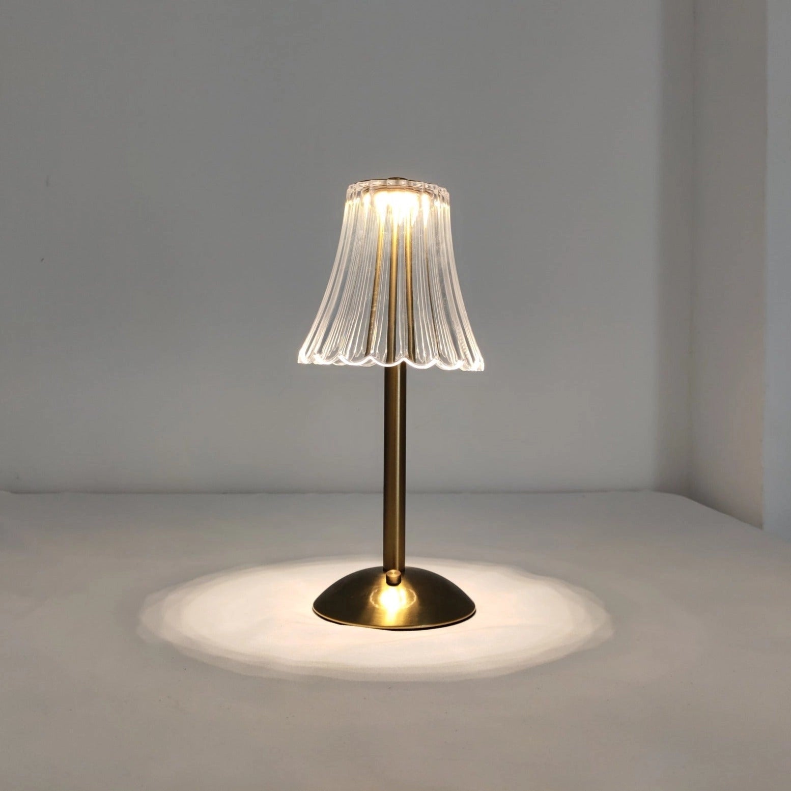 Elegant pleated table lamp with acrylic lampshade, modern gold base, and LED lighting.