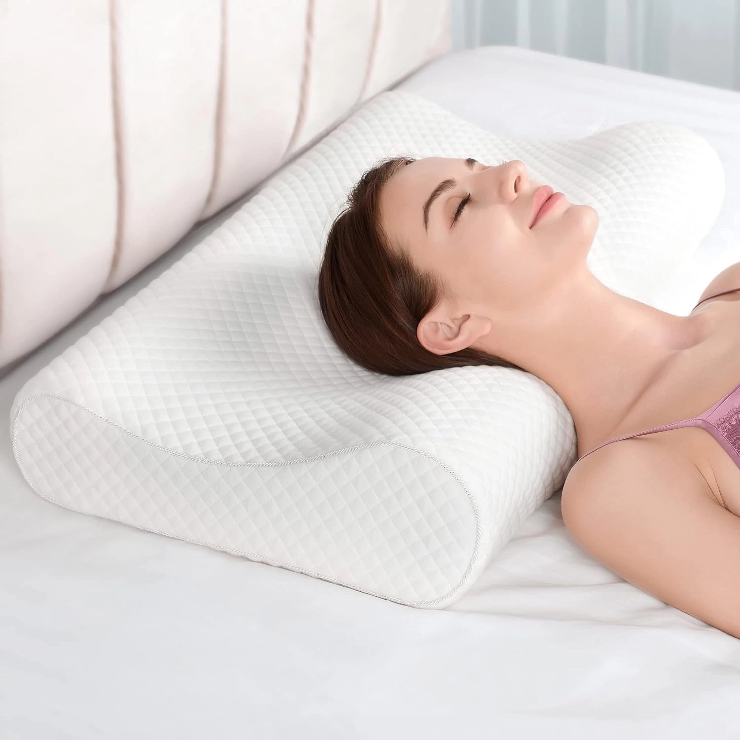 Ergonomic memory foam contour pillow providing cervical and neck support with a focus on comfort, shown supporting a person's head and neck while resting on a couch.