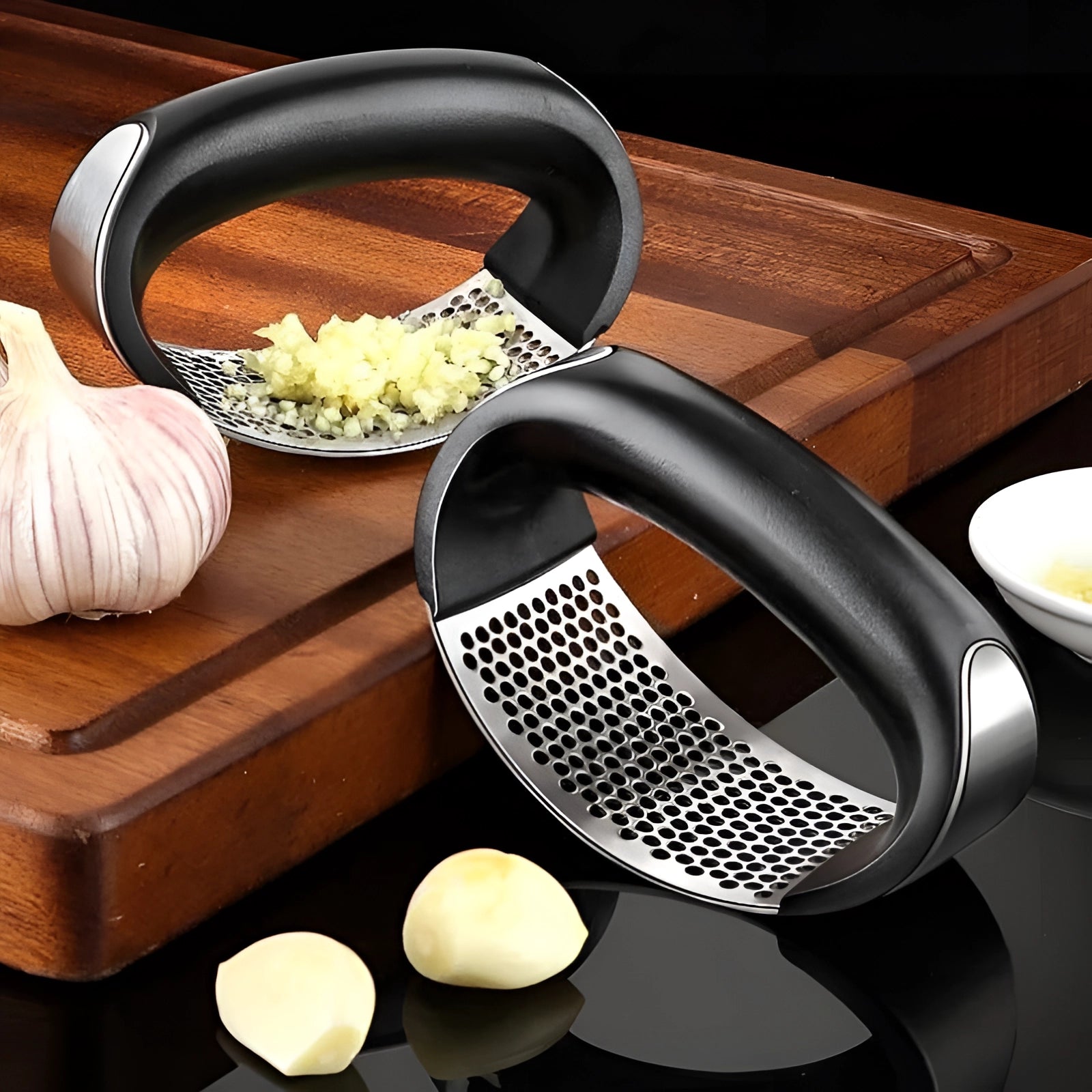 Ergonomic stainless steel garlic press on a wooden kitchen surface.