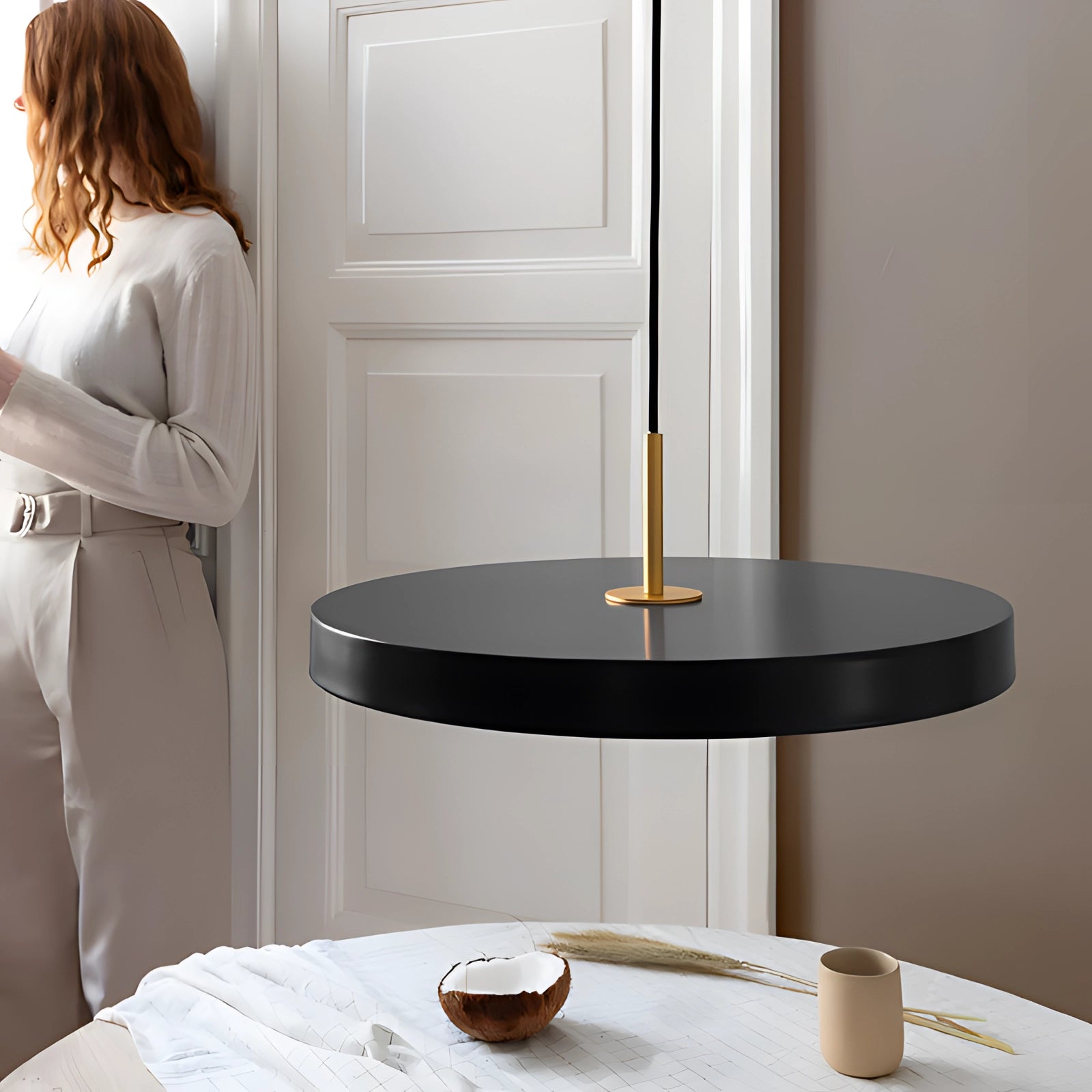 Floating black suspended round dining table with modern minimalist design, featuring a smooth surface and stylish setting with tableware, set against a white background.