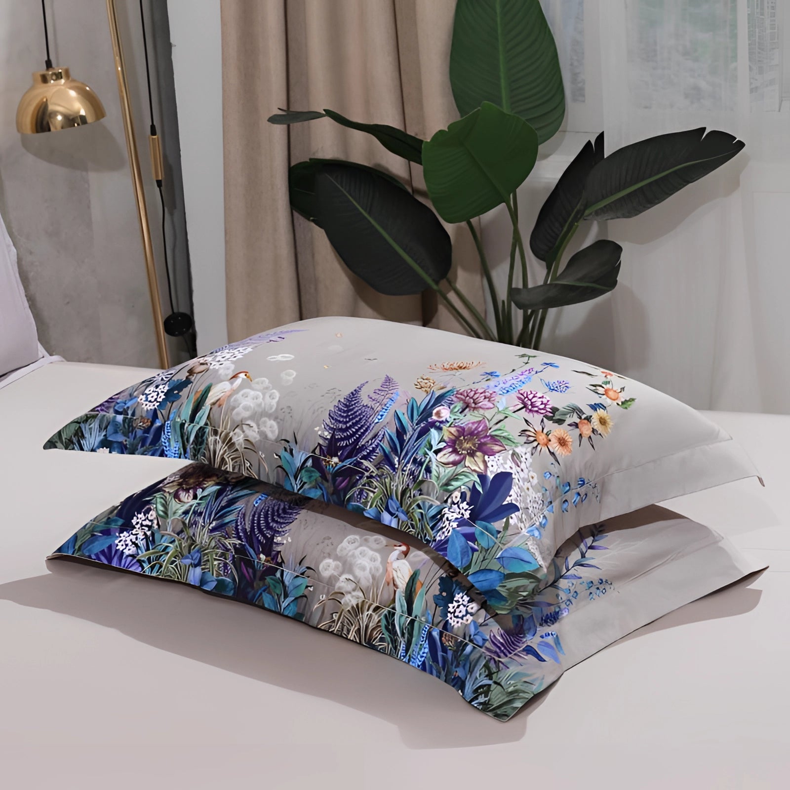 Elegant floral bedding set with a designer duvet and comforter, featuring a sophisticated interior design with decorative pillows and lush houseplants, creating a cozy and inviting bedroom ambiance.