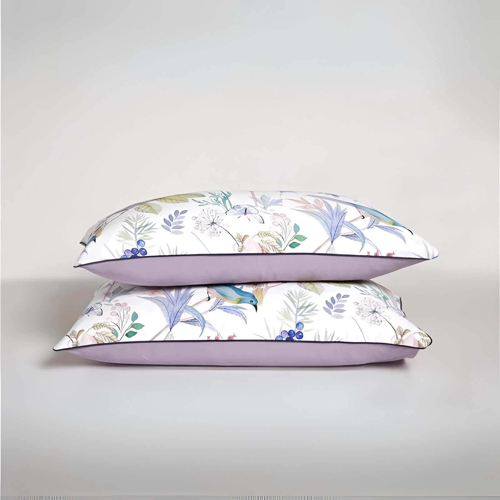 Floral botanical throw pillows featuring purple piping, designed for elegant home decor display.