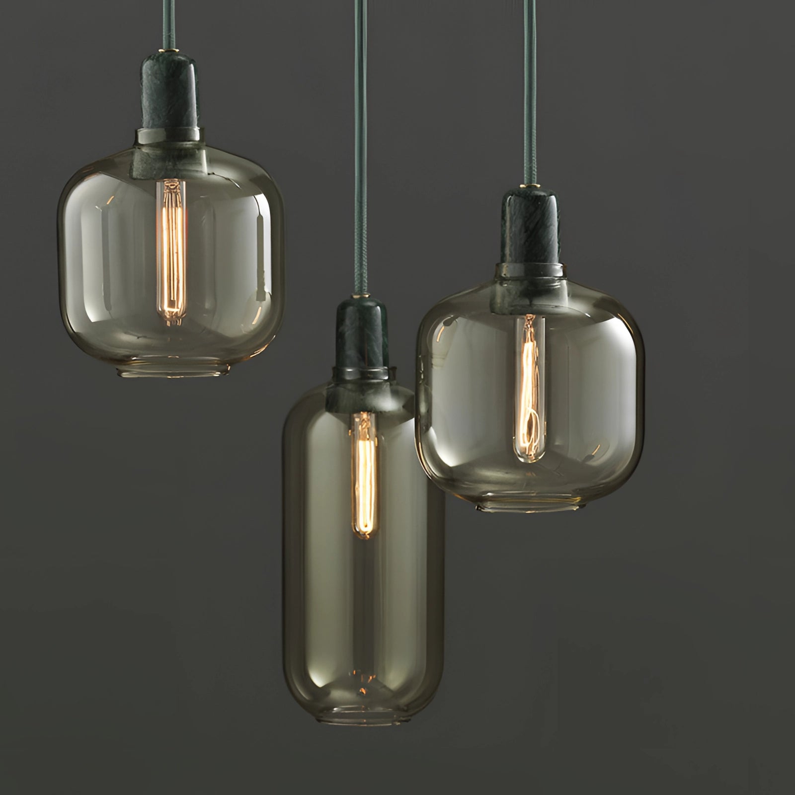 Frosted glass pendant light with brass accents, featuring a Scandinavian minimalist design, hanging from the ceiling.