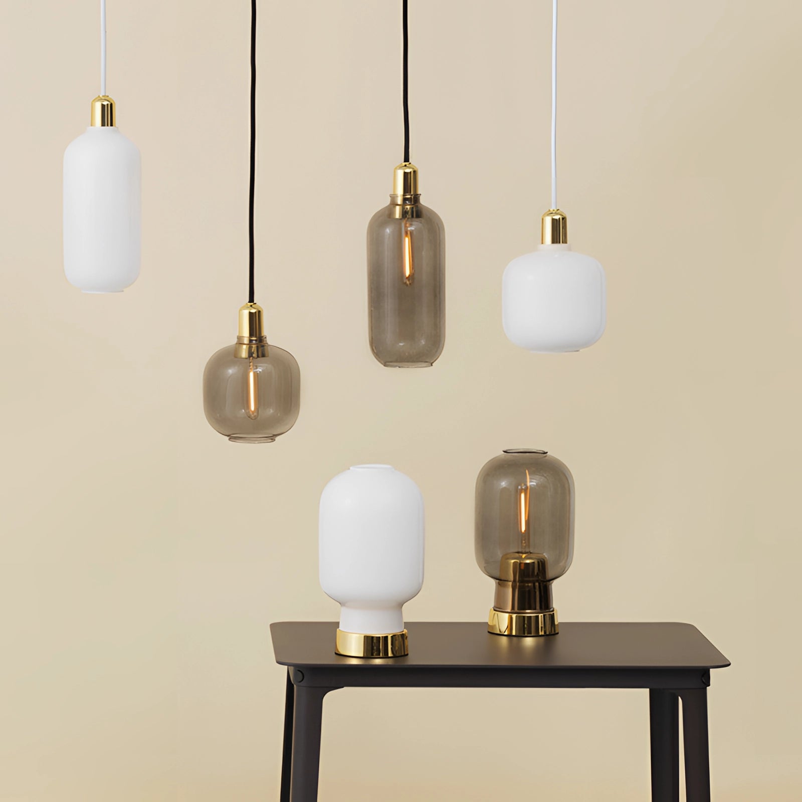 Frosted glass pendant light with a brass accent, showcasing a Scandinavian minimalist design, suspended above a wooden table.