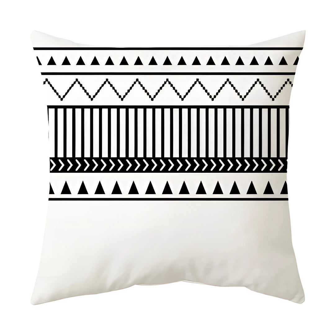 Black and white geometric throw pillow with modern abstract design featuring circles and rectangles, displayed on wooden bedding.