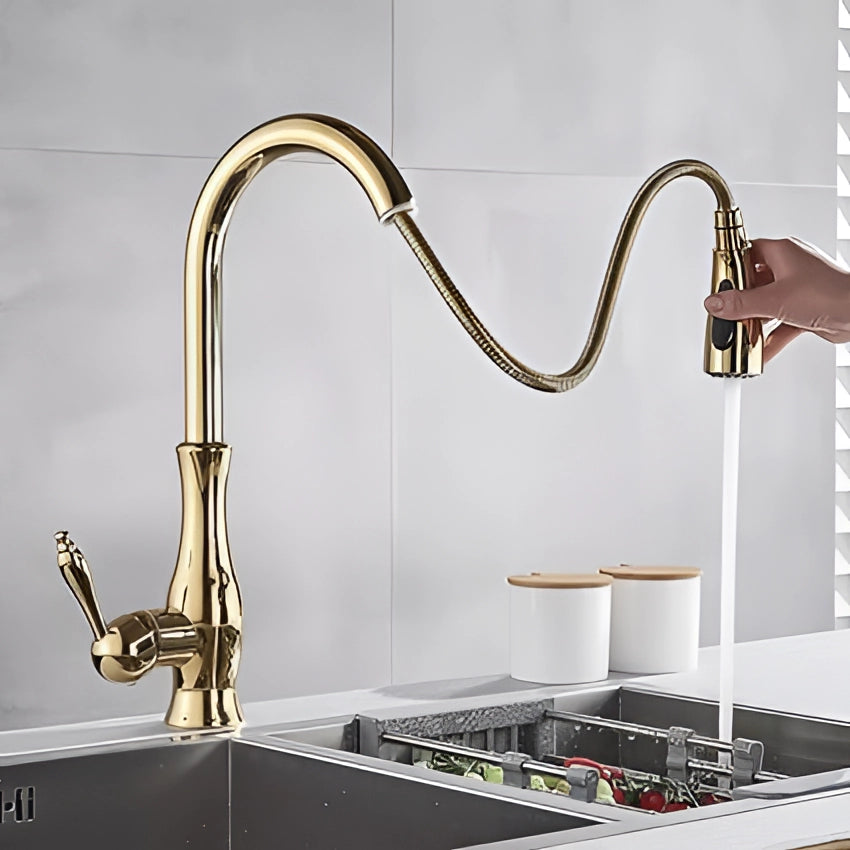 
Gold brass kitchen faucet with a pull-down spray feature and high-arc modern design, installed in a stylish kitchen setting with interior design elements.