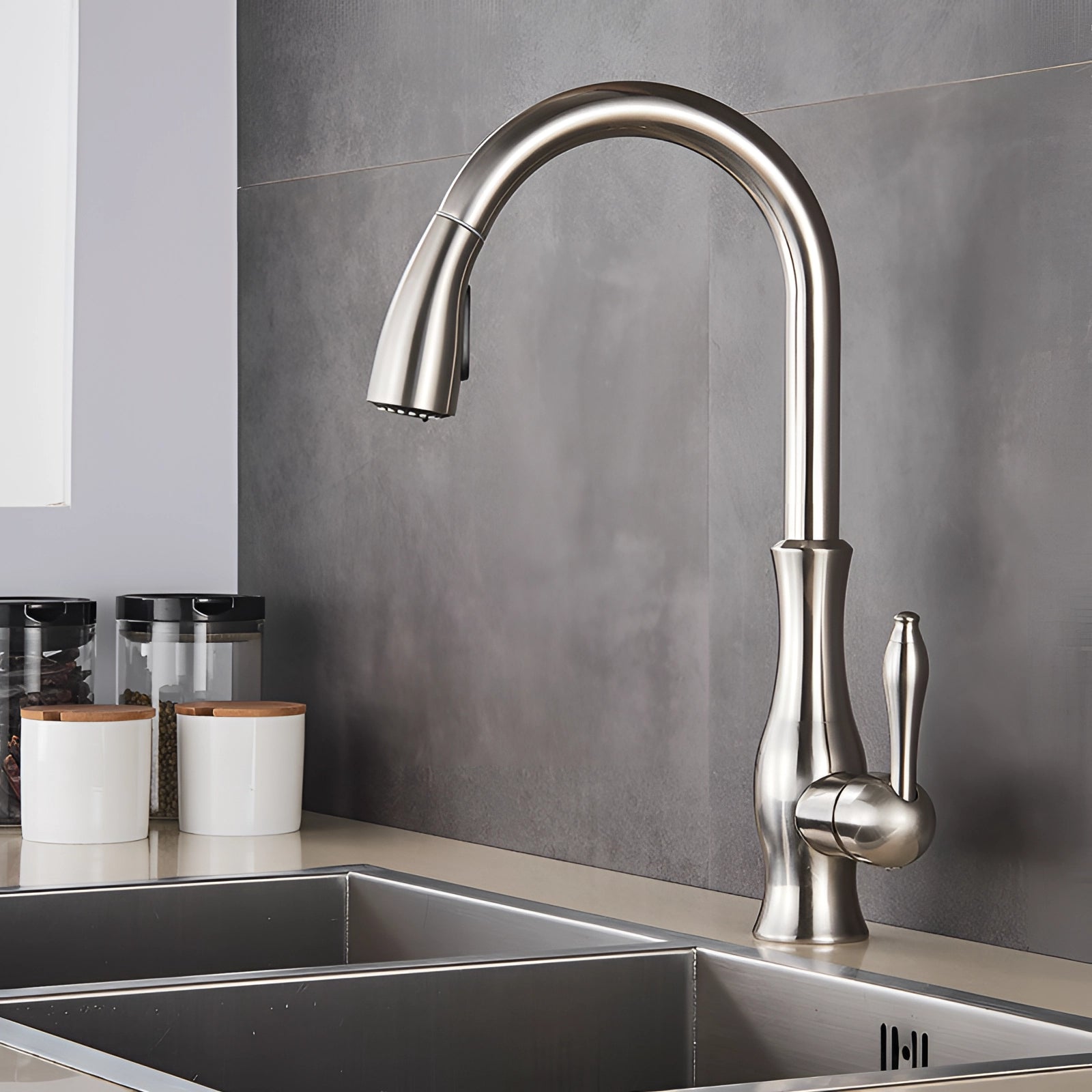 Modern gold brass kitchen faucet with a high-arc design and pull-down spray, installed over a grey bathroom sink, showcasing a sleek and contemporary interior design.