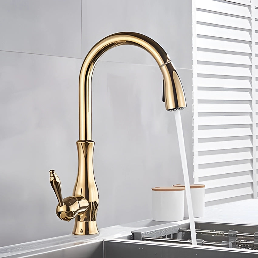 Gold brass high-arc kitchen faucet with a modern design, featuring a pull-down spray, installed above a white sink.