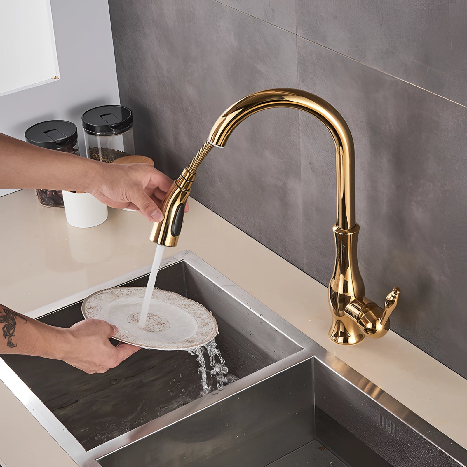 Gold brass kitchen faucet with a pull-down spray and high-arc design installed on a rectangular kitchen sink, situated on a countertop.