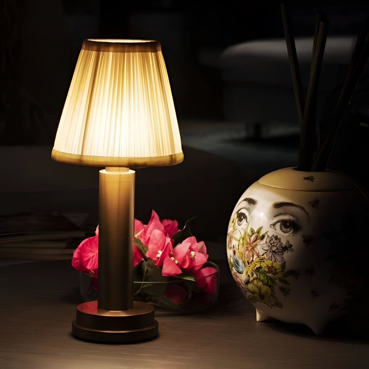 Luxury gold and brass designer table lamp with a rectangular lampshade, elegantly displayed on a wooden table in a stylishly designed interior setting, perfect for sophisticated bedside lighting.