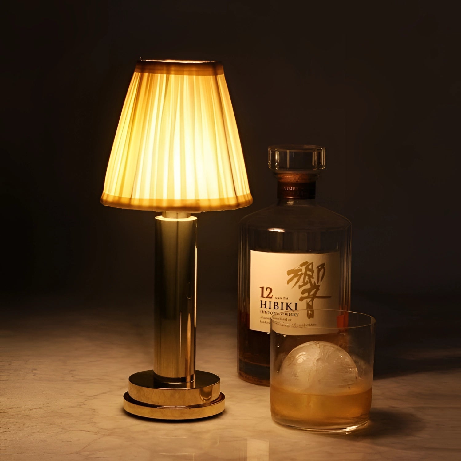 Elegant gold and brass designer table lamp with a luxurious finish, featuring a warm amber glow, ideal for bedside lighting.